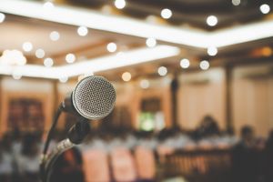 Microphone on abstract blurred conference hall